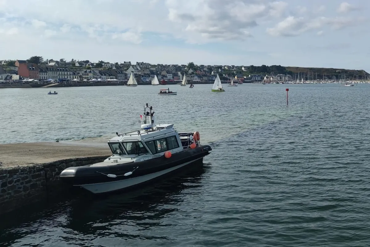 L'Océanite amarré le long d'une cale, voiliers et maisons du port en arrière-plan