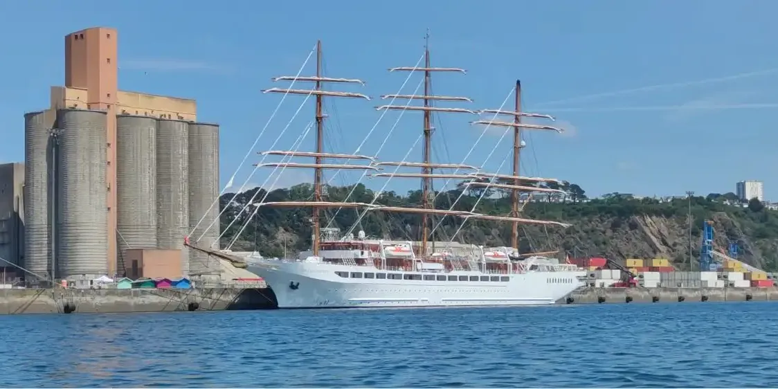 Grand voilier trois-mâts à quai devant les silos du port de commerce de Brest